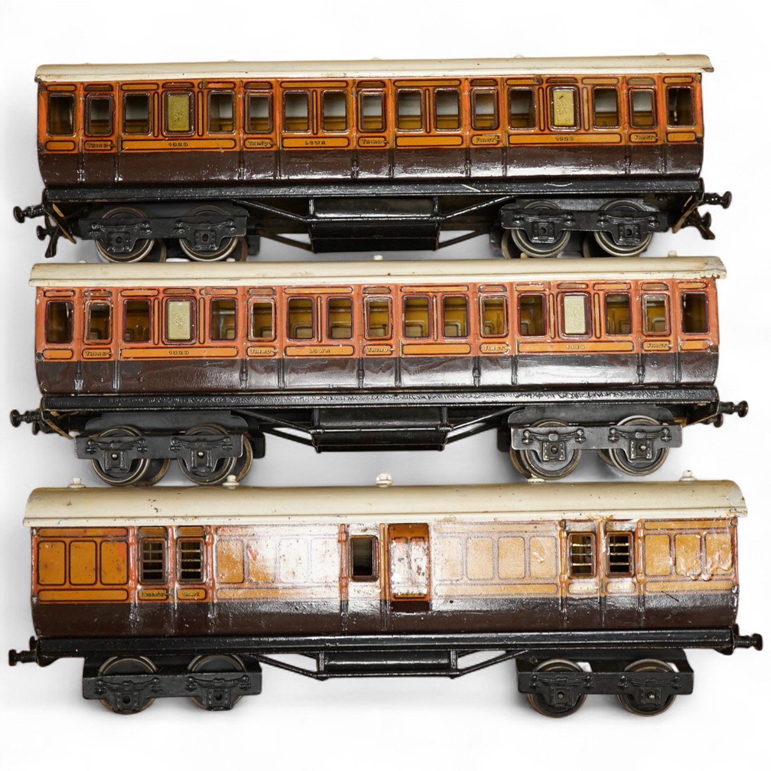 Three Carette for Bassett-Lowke 0 gauge railway 1921 series tinplate LSWR bogie coaches fitted with Bing couplings; two First Third Composite coaches, both 1328, and a full brake van, 133, all in salmon and chocolate liv